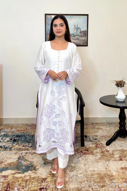 Front view of the off-white chanderi straight kurta with floral cutwork embroidery on the sleeves and hem, paired with off-white trousers.
