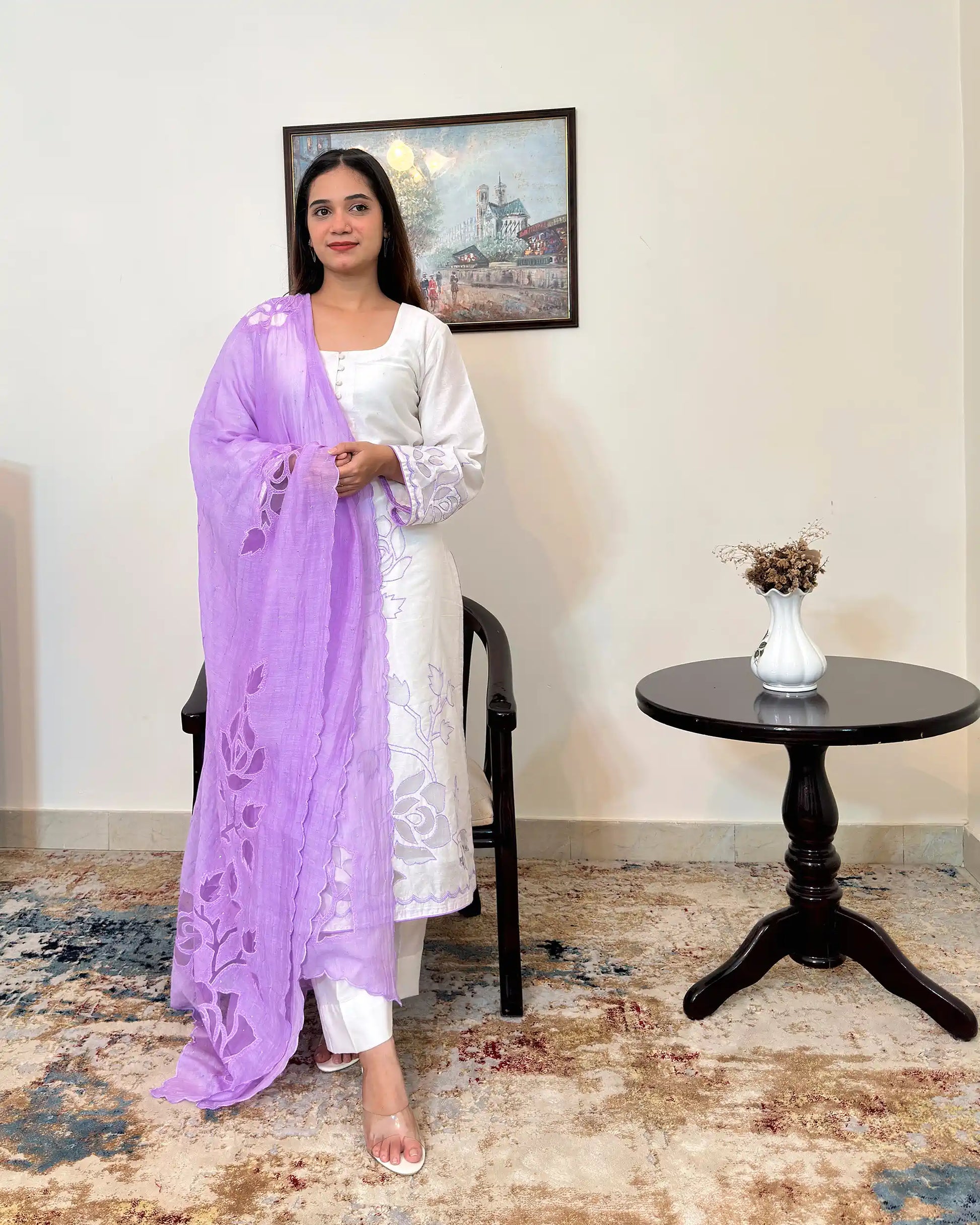 Front view of the off-white chanderi straight kurta with floral cutwork embroidery, paired with the purple chanderi dupatta with floral cutwork and off-white trousers, dupatta on.