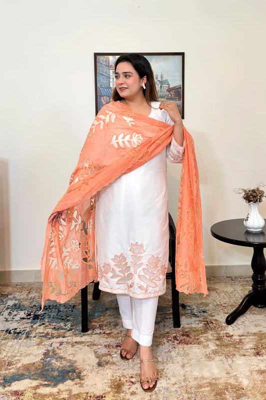 Front view of an off-white chanderi straight kurta with floral cutwork on the sleeves and hem, worn with a peach dupatta featuring floral cutwork, dupatta on, and off-white trousers.