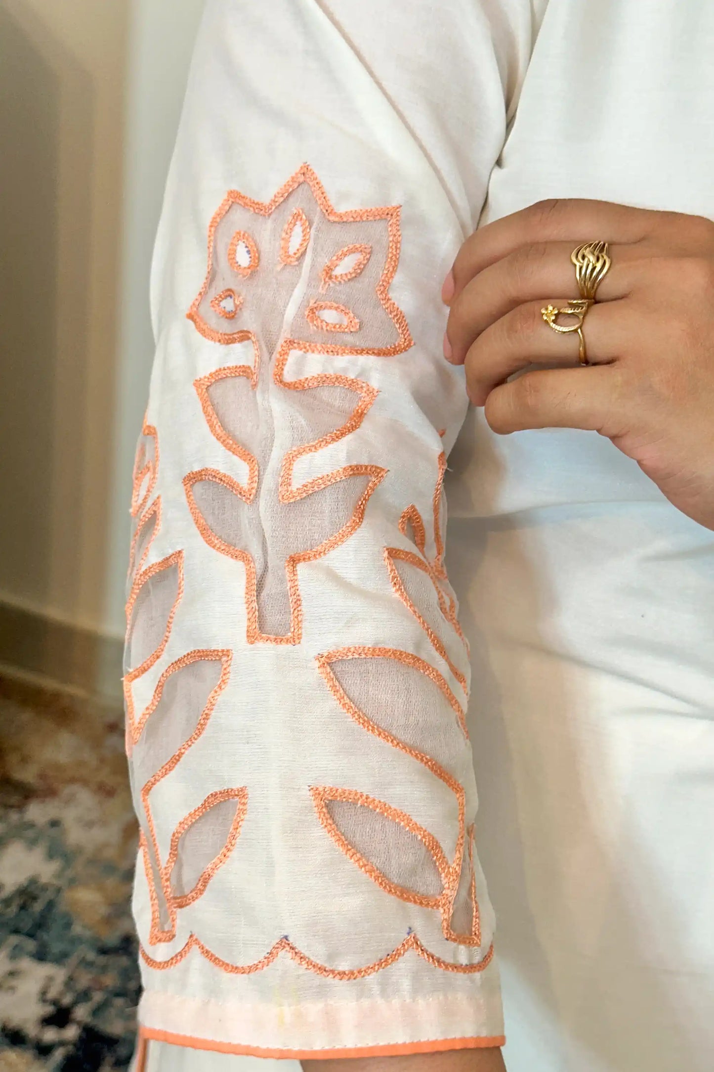 Close-up of the sleeve of the off-white chanderi kurta showing floral cutwork detailing.