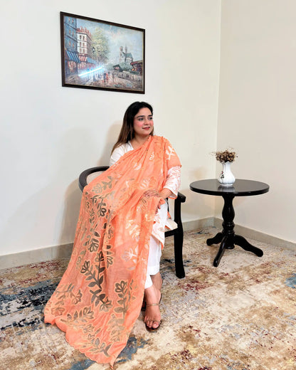 Front view of the off-white chanderi straight kurta with floral cutwork on the sleeve, worn with a peach dupatta featuring floral cutwork, and off-white trousers.