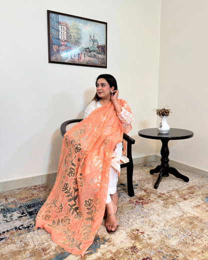 Front view of the off-white chanderi straight kurta with floral cutwork on the sleeve, worn with a peach dupatta featuring floral cutwork, and off-white trousers.