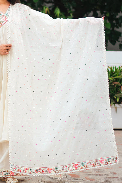 Indian model holding an off-white cotton dupatta with multicolored Kashmiri embroidery and lace detailing around the edges.