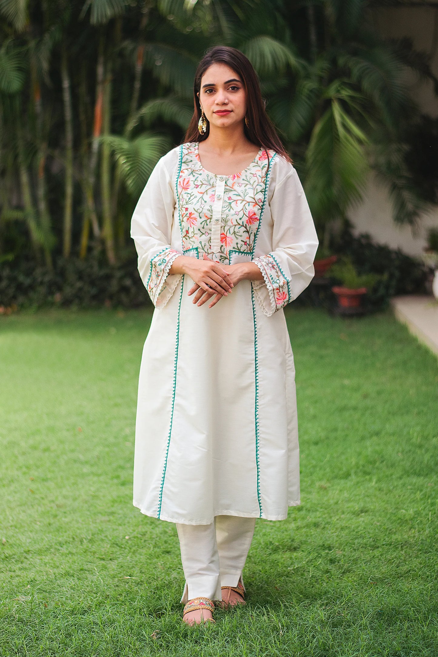 Indian model wearing an off-white cotton kalidar kurta with Kashmiri embroidery, paired with off-white trousers.