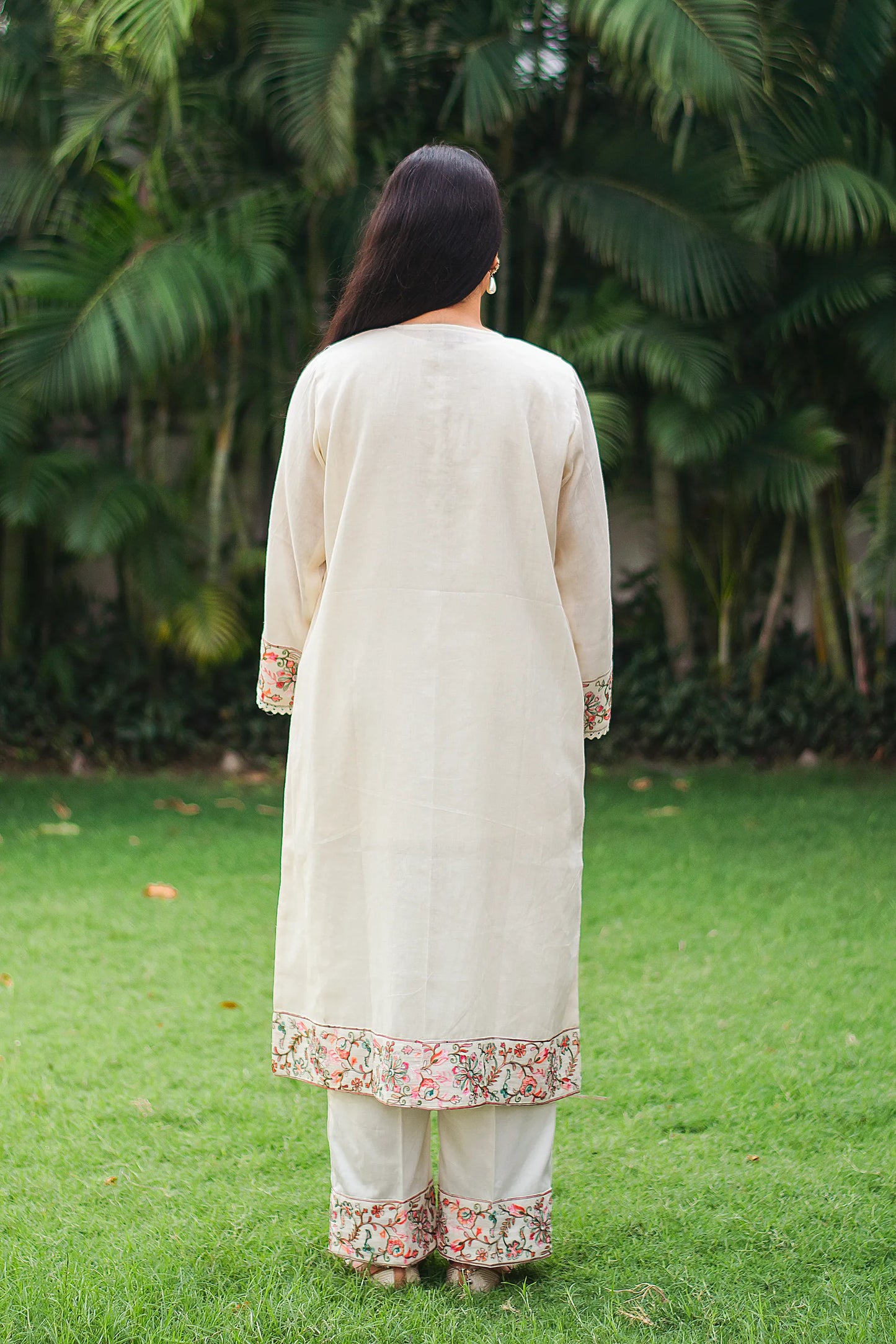 Back view of Indian model in an off-white cotton kurta with Kashmiri embroidery.