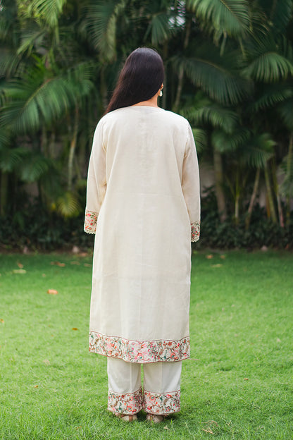 Back view of Indian model in an off-white cotton kurta with Kashmiri embroidery.