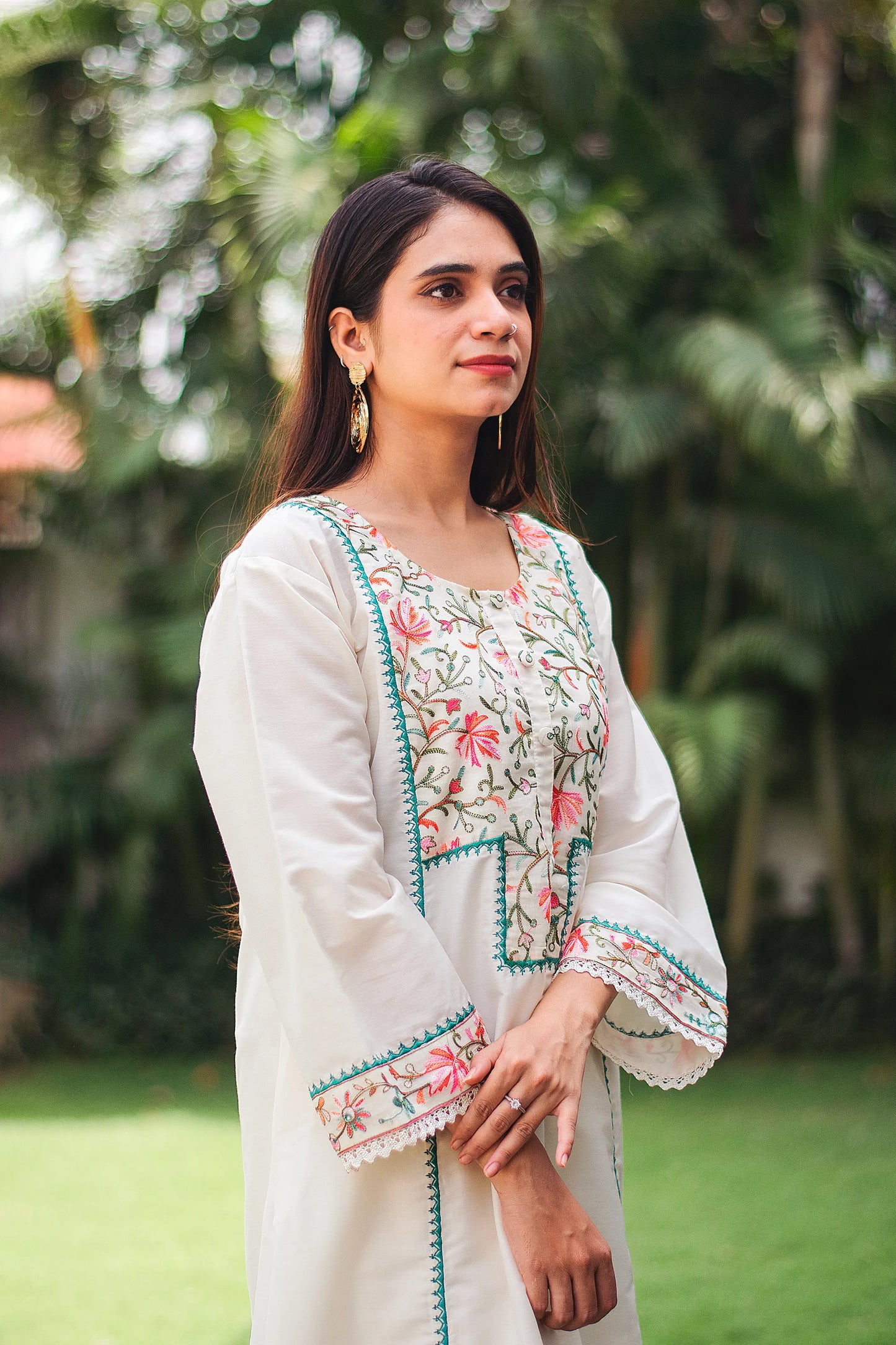 Side view of an Indian model in an off-white cotton kurta with Kashmiri embroidery