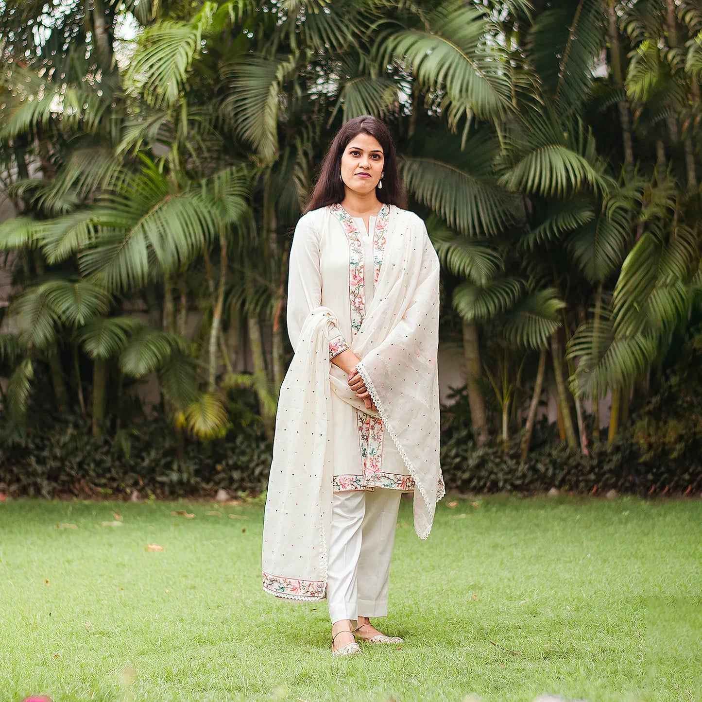 Indian model in an elegant off-white tunic and trousers set adorned with intricate Kashmiri embroidery, paired with a matching embroidered dupatta