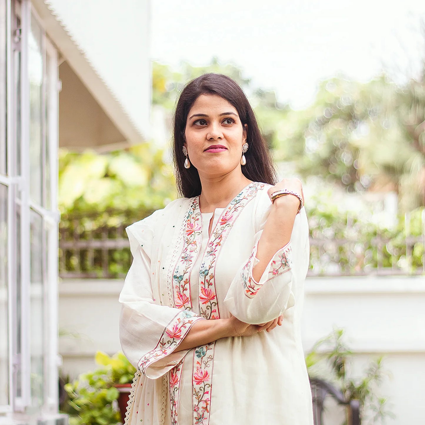 Indian model wearing an off-white tunic and trousers set with delicate Kashmiri embroidery