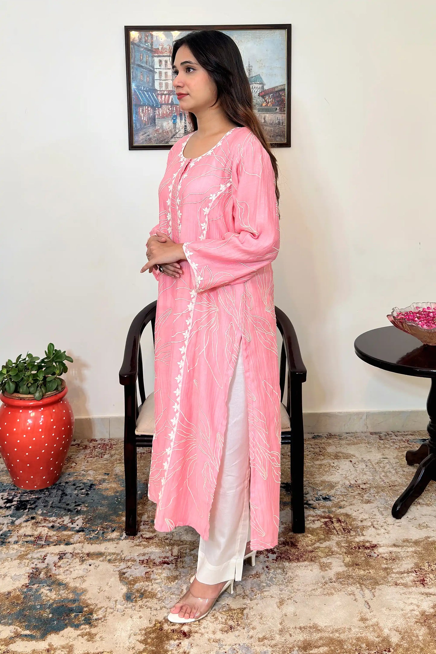 Left side view of the model wearing the pink chanderi kalidar kurta with floral resham embroidery, off-white cotton-silk trousers, and the pink chanderi dupatta draped over the shoulder, showing the side slit.