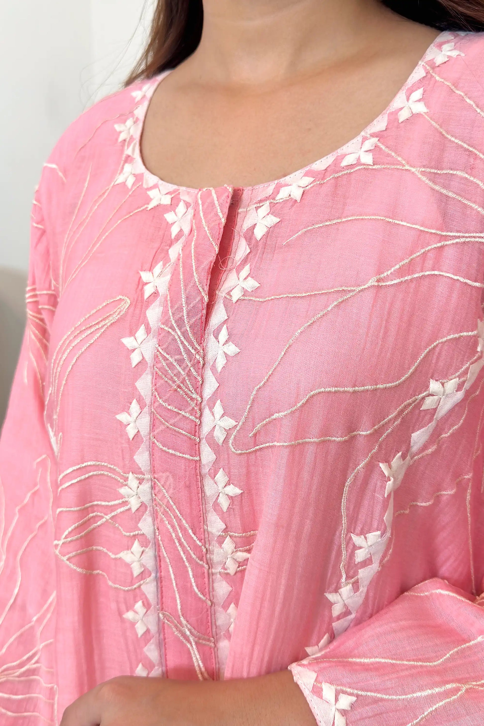 Close-up of the neckline and button placket, showing off-white applique diamond motifs along the placket and resham embroidery on the surrounding fabric.