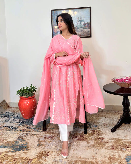 Model standing and holding the pink chanderi dupatta open with both hands, showing the scattered embroidered dots and off-white applique border across its length.