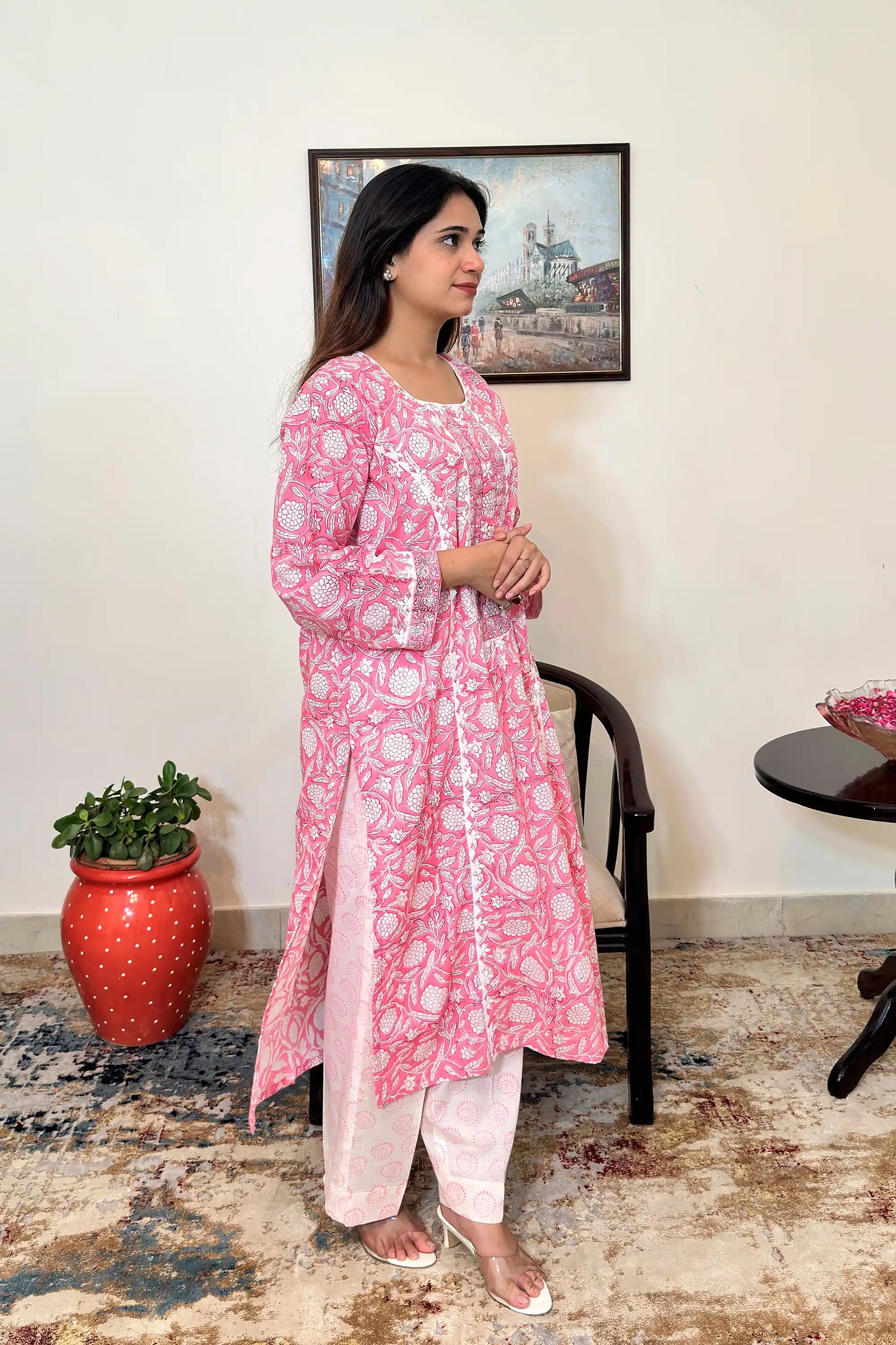 Right side view of the model wearing the pink floral block-printed mulmul cotton kalidar kurta and off-white printed trousers, showing the side slit and kurta hem.