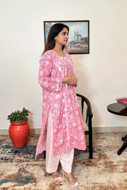 Right side view of the model wearing the pink floral block-printed mulmul cotton kalidar kurta and off-white printed trousers, showing the side slit and kurta hem.