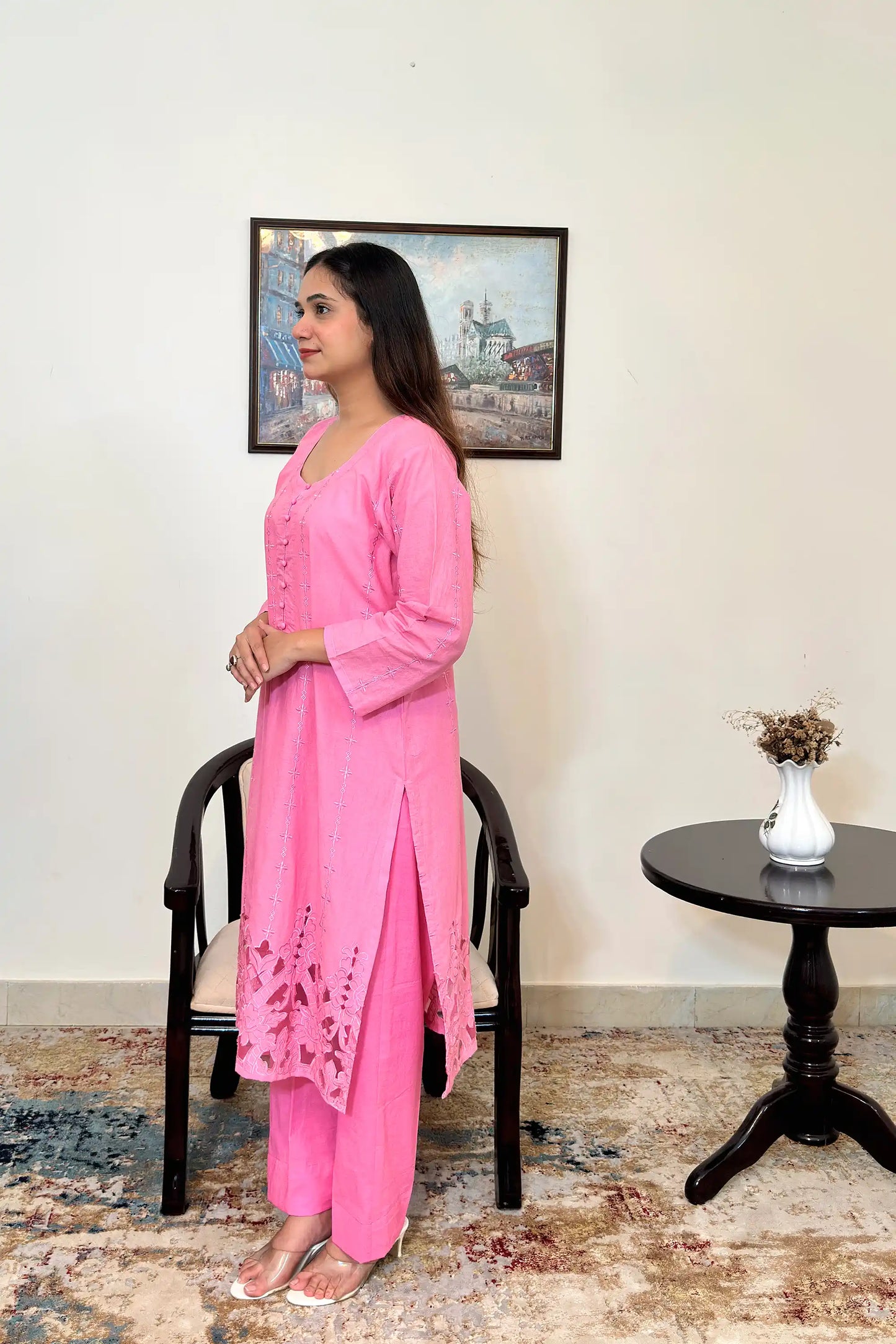 Left side view of the model wearing the pink cotton straight kurta and pink trousers, showing the side slit and the floral cutwork hem.