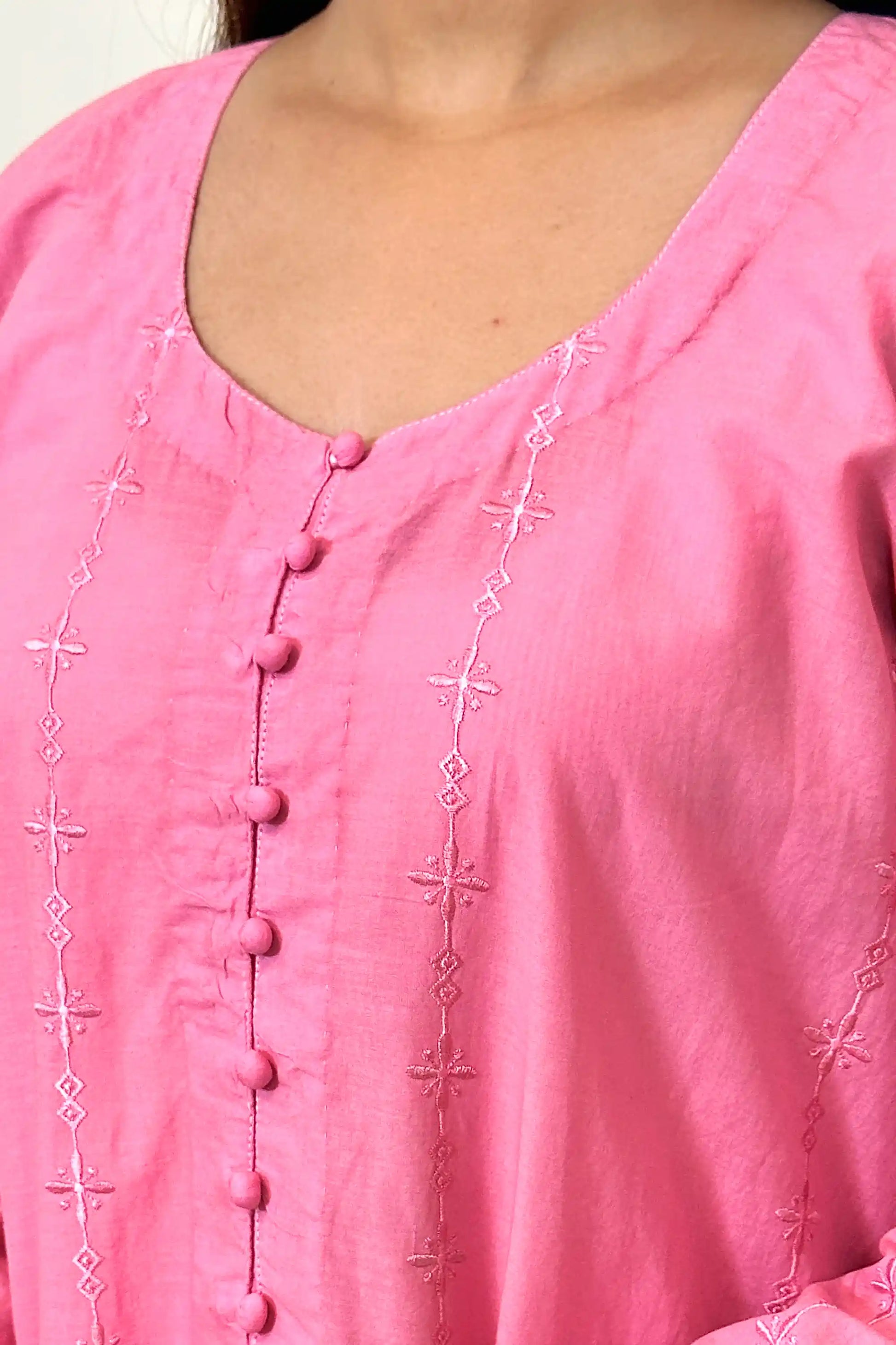 Close-up of the button placket and neckline, showing the embroidered diamond and star motifs along the front panel.