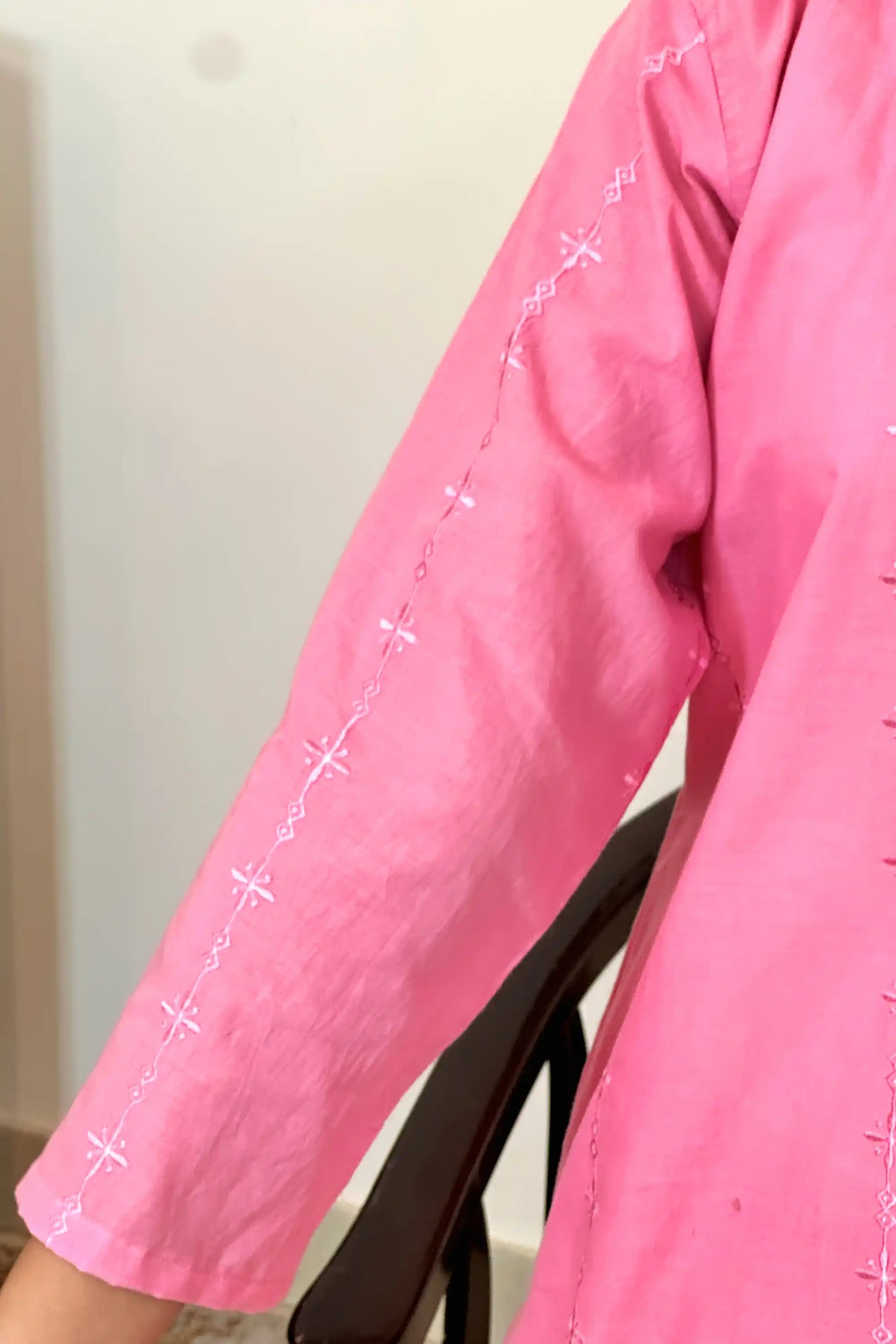 Close-up of the sleeve, showing the embroidered diamond and star motifs running down its length.