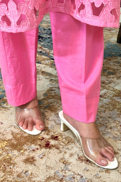 Close-up of the kurta's floral cutwork hem meeting the pink trousers.