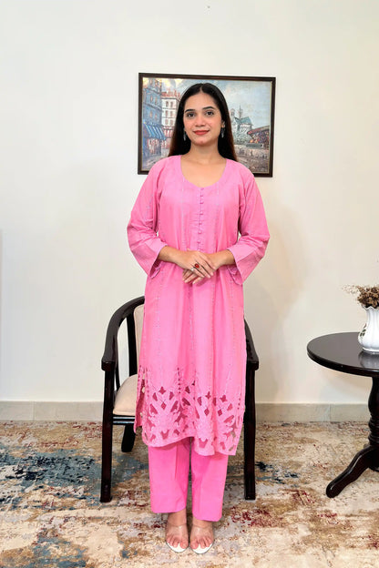 Front view of the pink cotton straight kurta and pink trousers, showing the embroidered diamond and star motifs down the front panels and the floral cutwork hem.