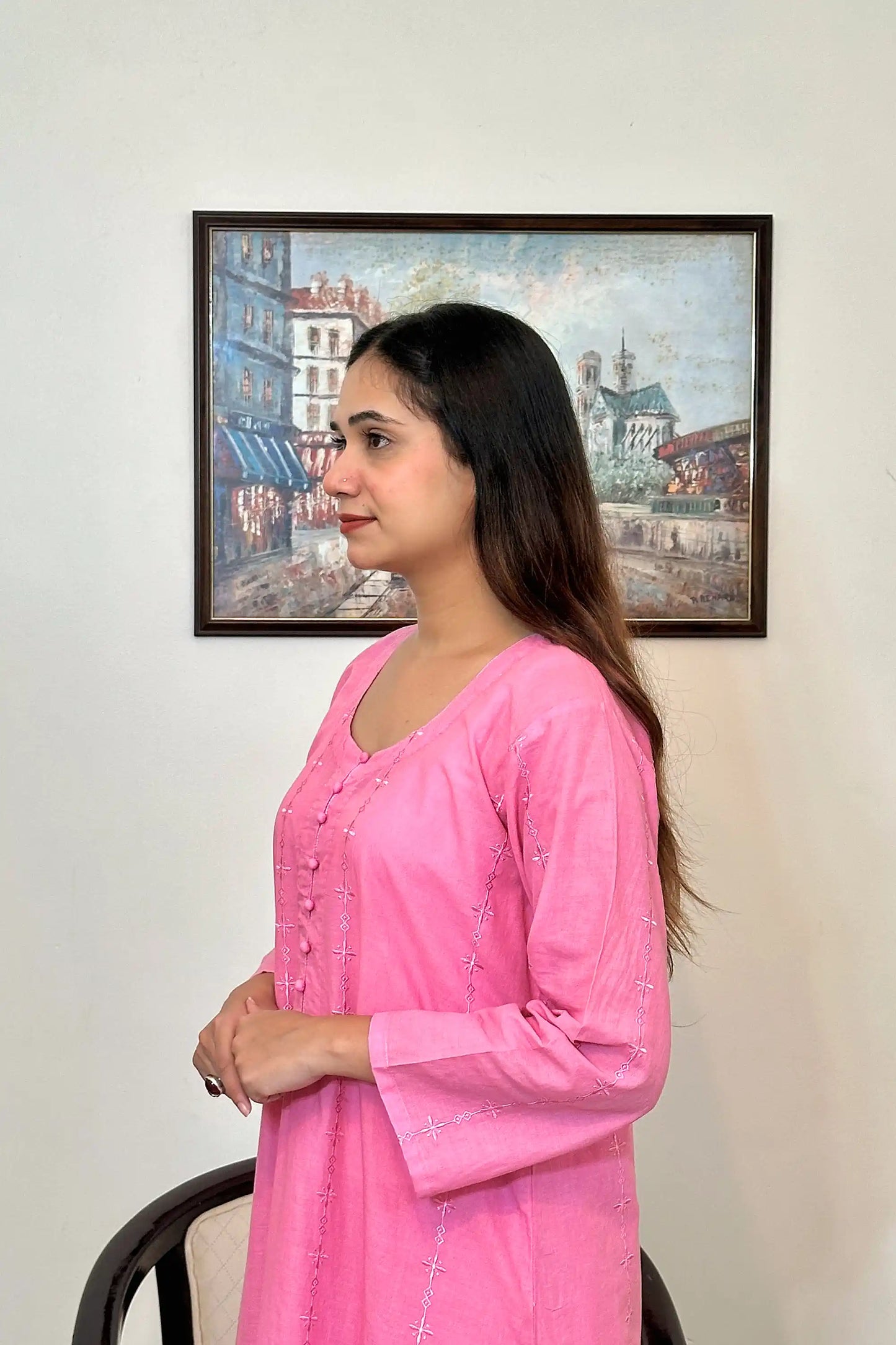 Left side view of the model showing the pink cotton straight kurta's upper half, with the embroidered diamond and star motifs visible along the front panel.