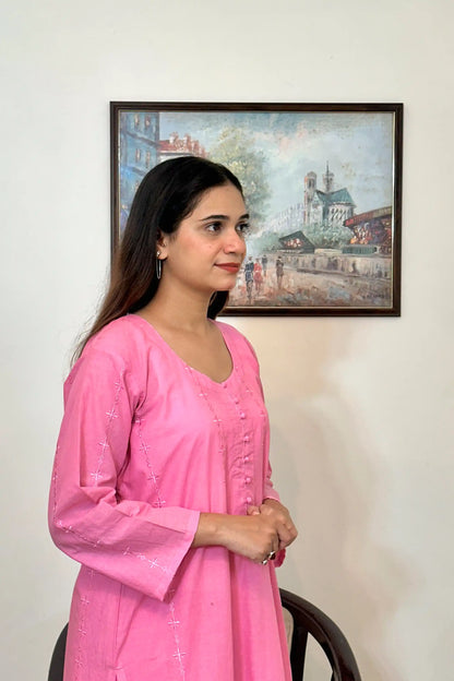 Right side view of the model showing the pink cotton straight kurta's upper half, with the sleeve and embroidered diamond and star motifs visible.