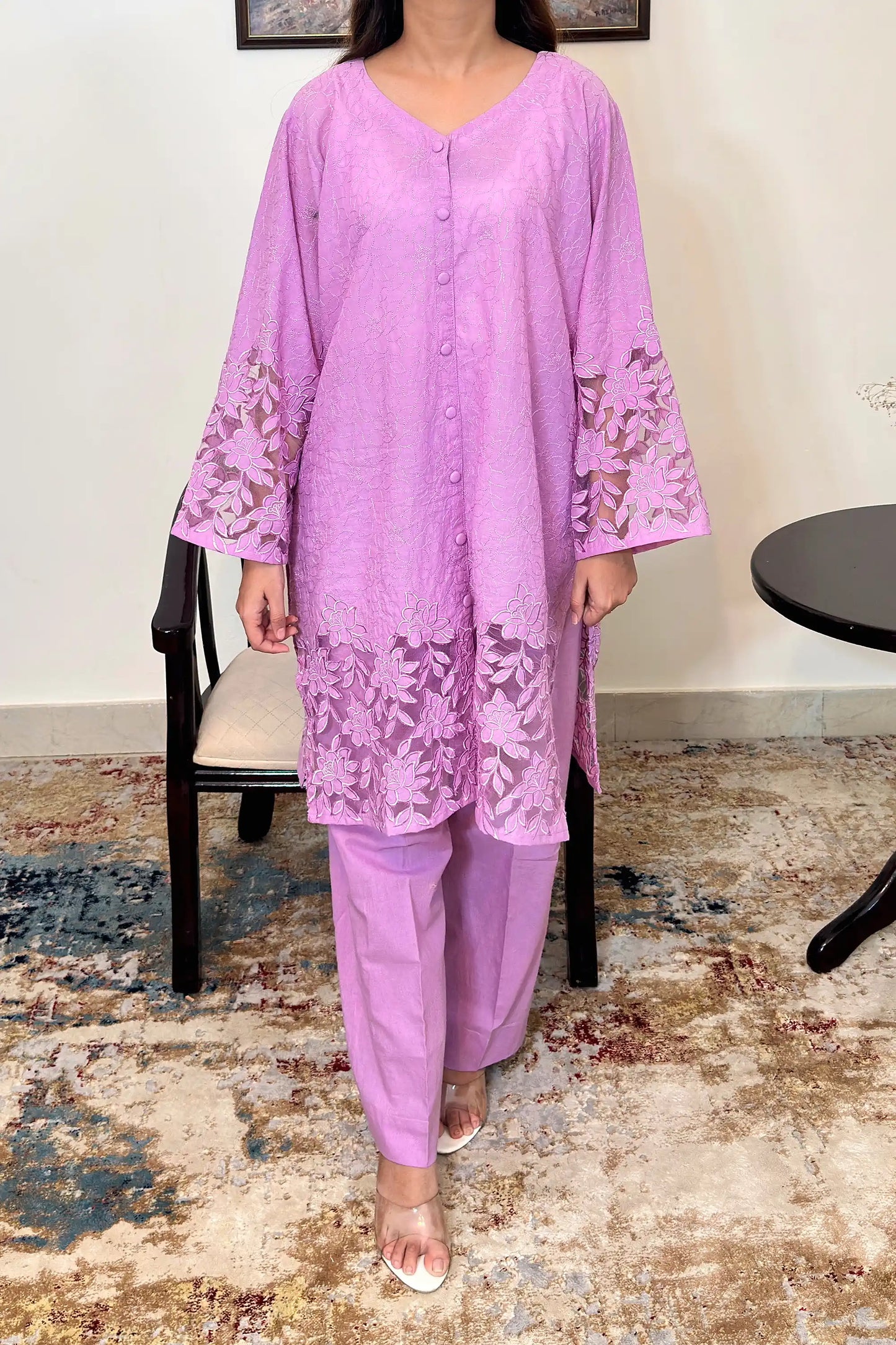 Front view of a purple cotton straight kurta, worn with purple trousers, featuring floral cutwork embroidery at the sleeves and hem.