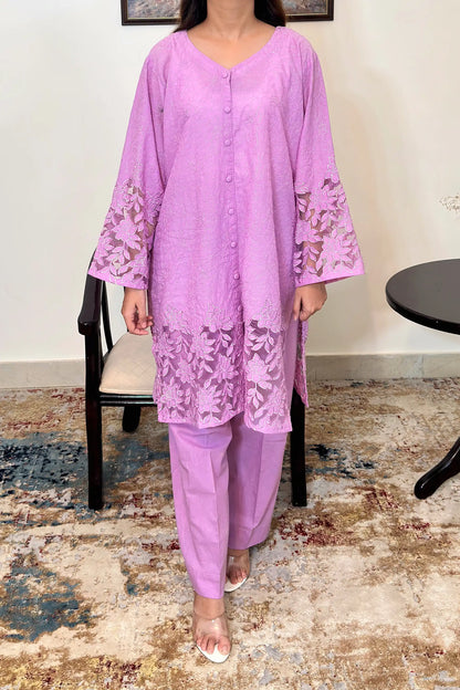 Front view of a purple cotton straight kurta, worn with purple trousers, featuring floral cutwork embroidery at the sleeves and hem.