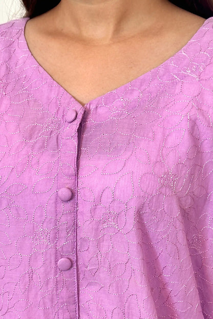 Close-up button placket view of a purple cotton kurta showing floral embroidery detail and covered buttons.