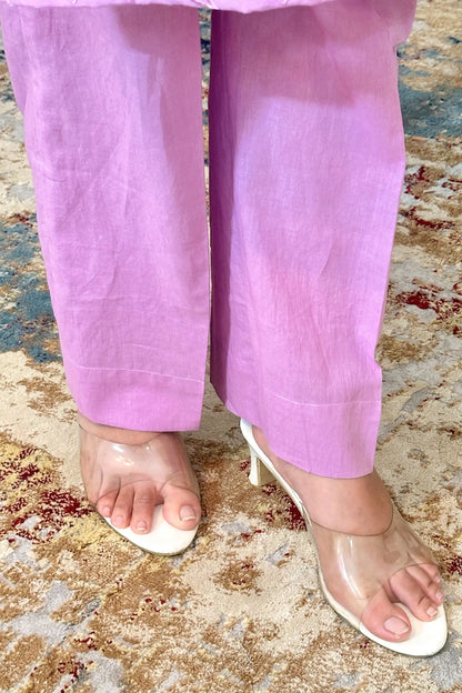 Close-up hem and trousers view of purple cotton trousers with a purple kurta hem in the background.