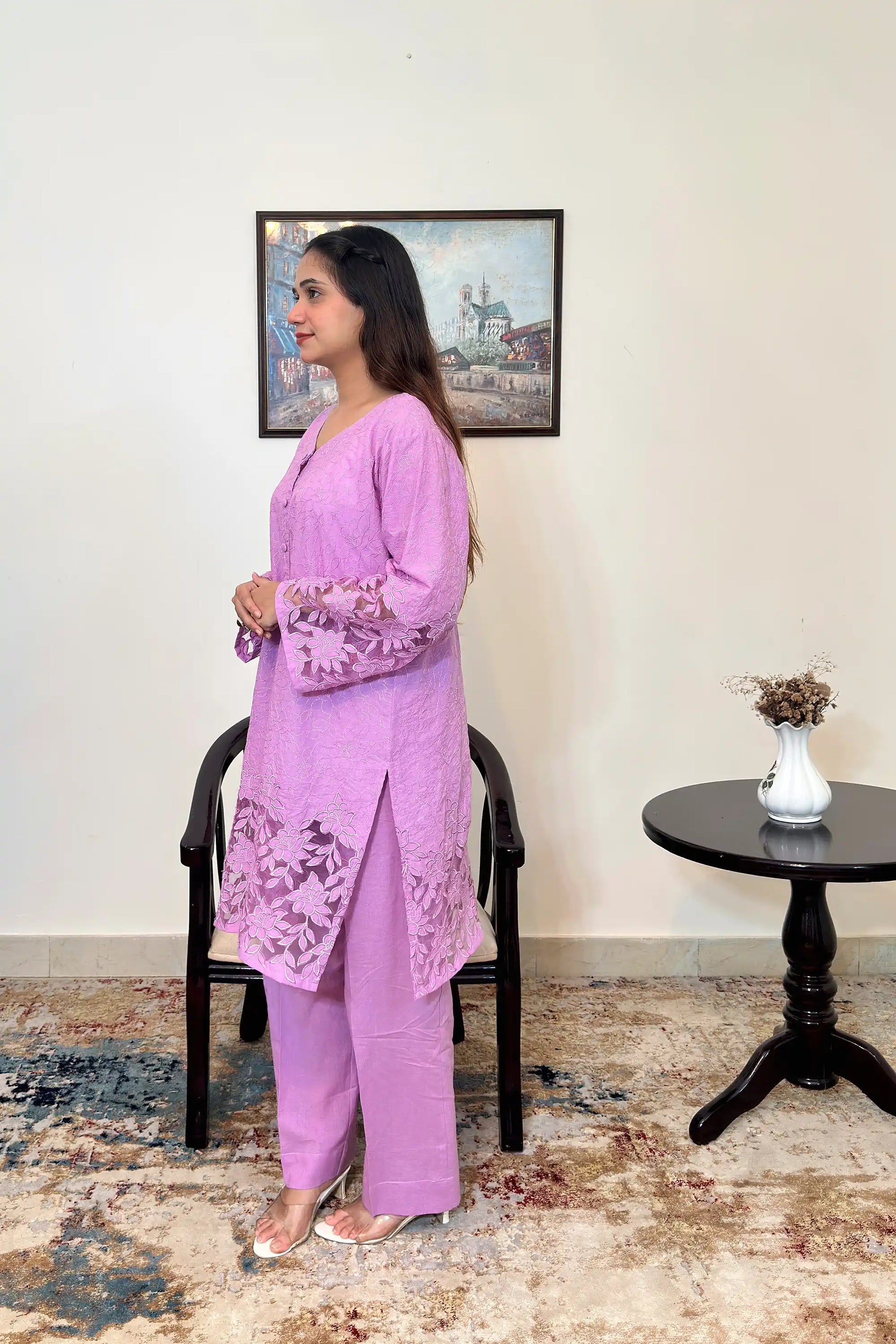 Side view of a purple cotton straight kurta, worn with purple trousers, featuring floral cutwork embroidery at the sleeves and hem.