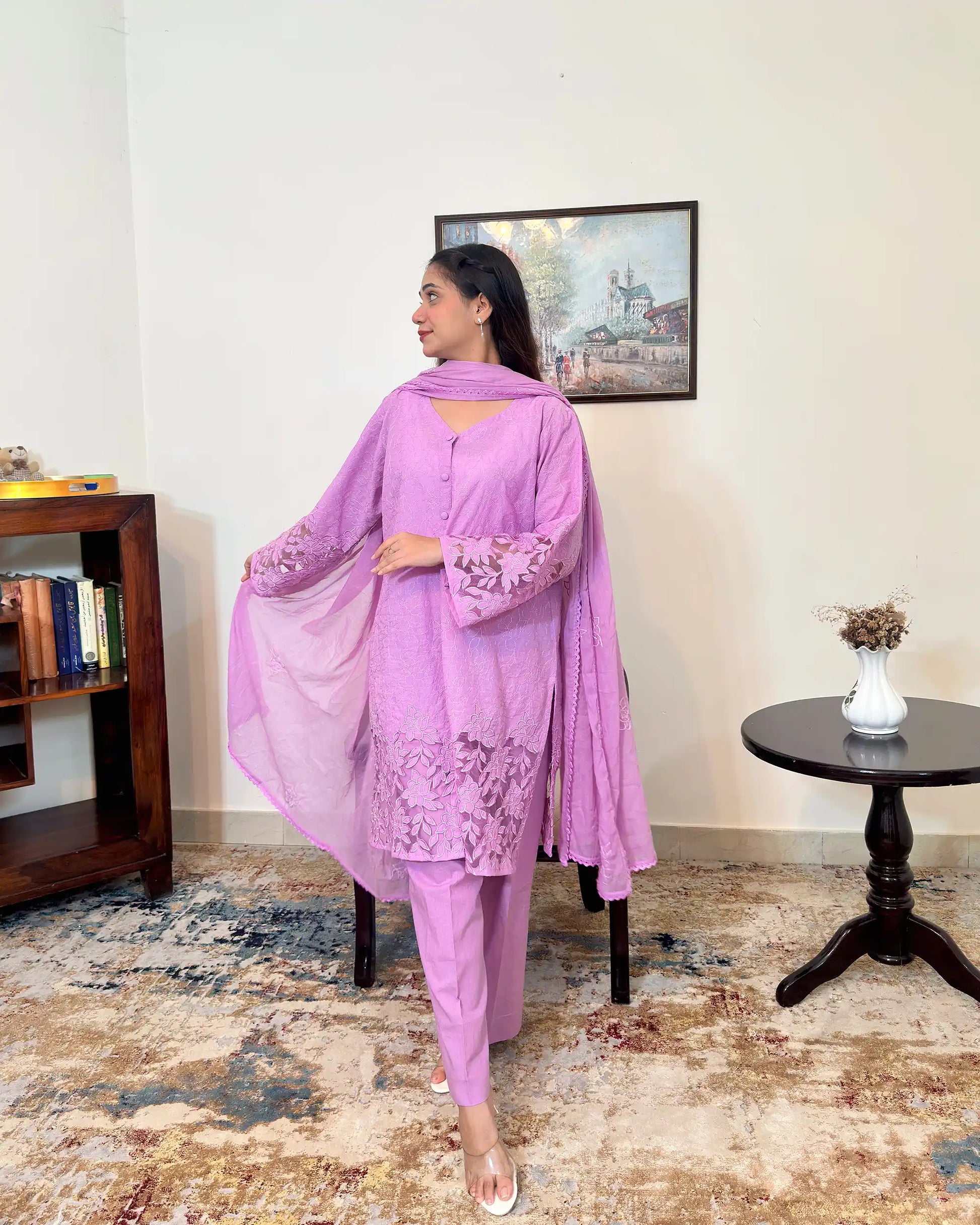 Side view of a purple cotton straight kurta with dupatta, worn with purple trousers, featuring floral cutwork embroidery on the sleeves and hem, and floral embroidery on the dupatta.