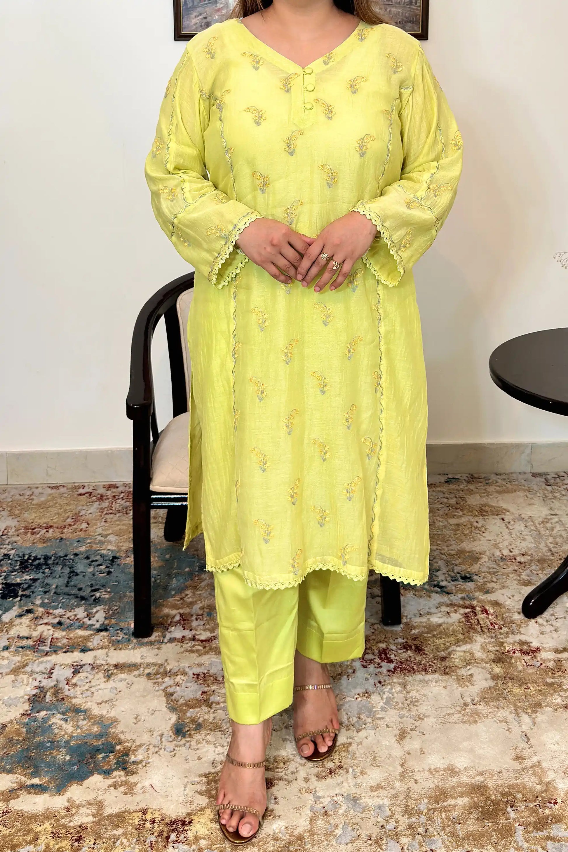 Front view of a lemon-yellow chanderi kalidar kurta showing floral resham embroidery on the kurta and matching lemon-yellow trousers.