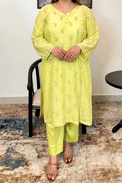 Front view of a lemon-yellow chanderi kalidar kurta showing floral resham embroidery on the kurta and matching lemon-yellow trousers.