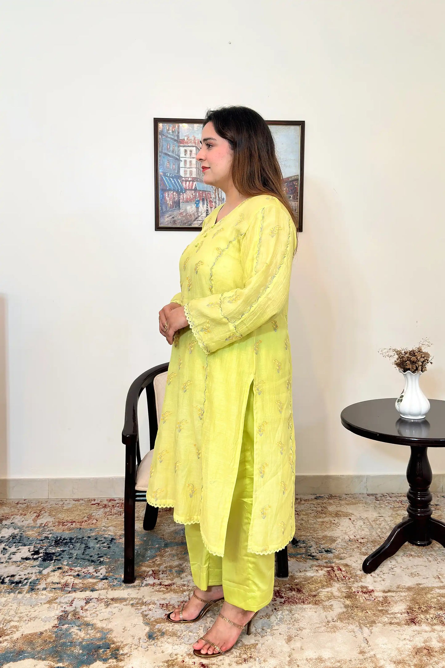 Side view of a lemon-yellow chanderi kalidar kurta, showing floral resham embroidery and matching lemon-yellow trousers.
