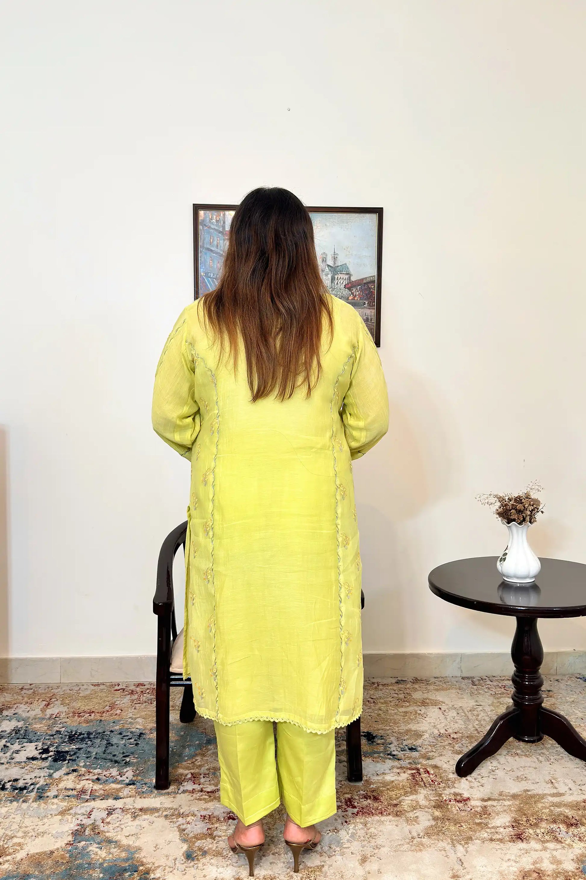 Back view of a lemon-yellow chanderi kalidar kurta, showing floral resham embroidery along the back panels and matching lemon-yellow trousers.