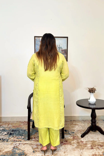 Back view of a lemon-yellow chanderi kalidar kurta, showing floral resham embroidery along the back panels and matching lemon-yellow trousers.