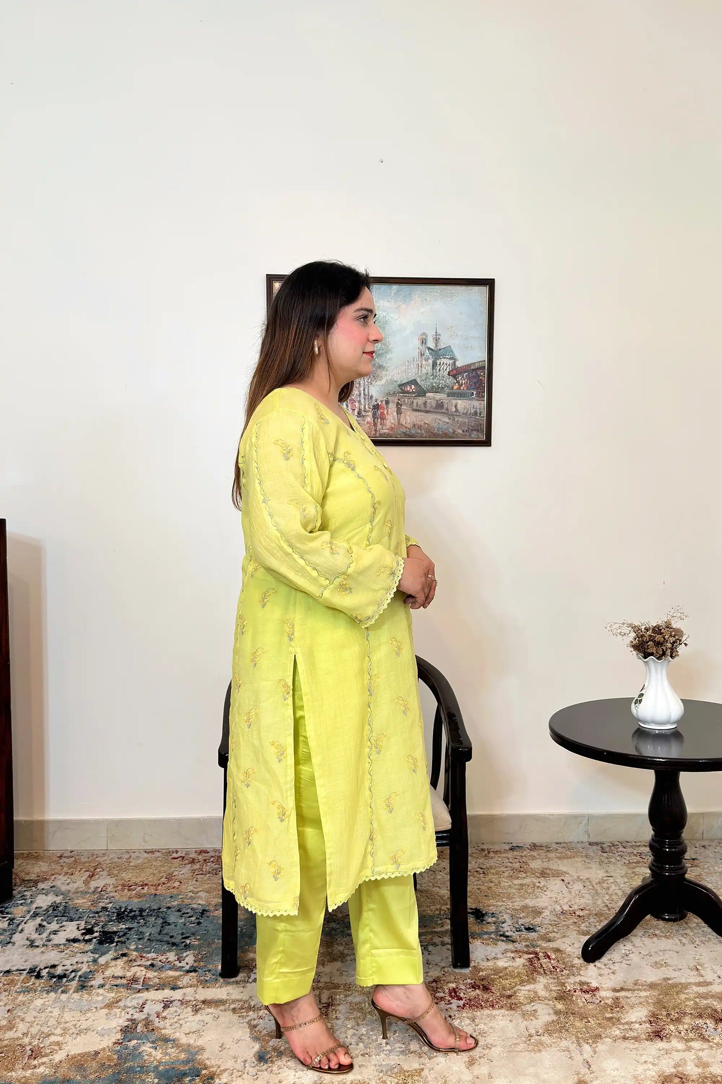 Side view of a lemon-yellow chanderi kalidar kurta, showing floral resham embroidery and matching lemon-yellow trousers.
