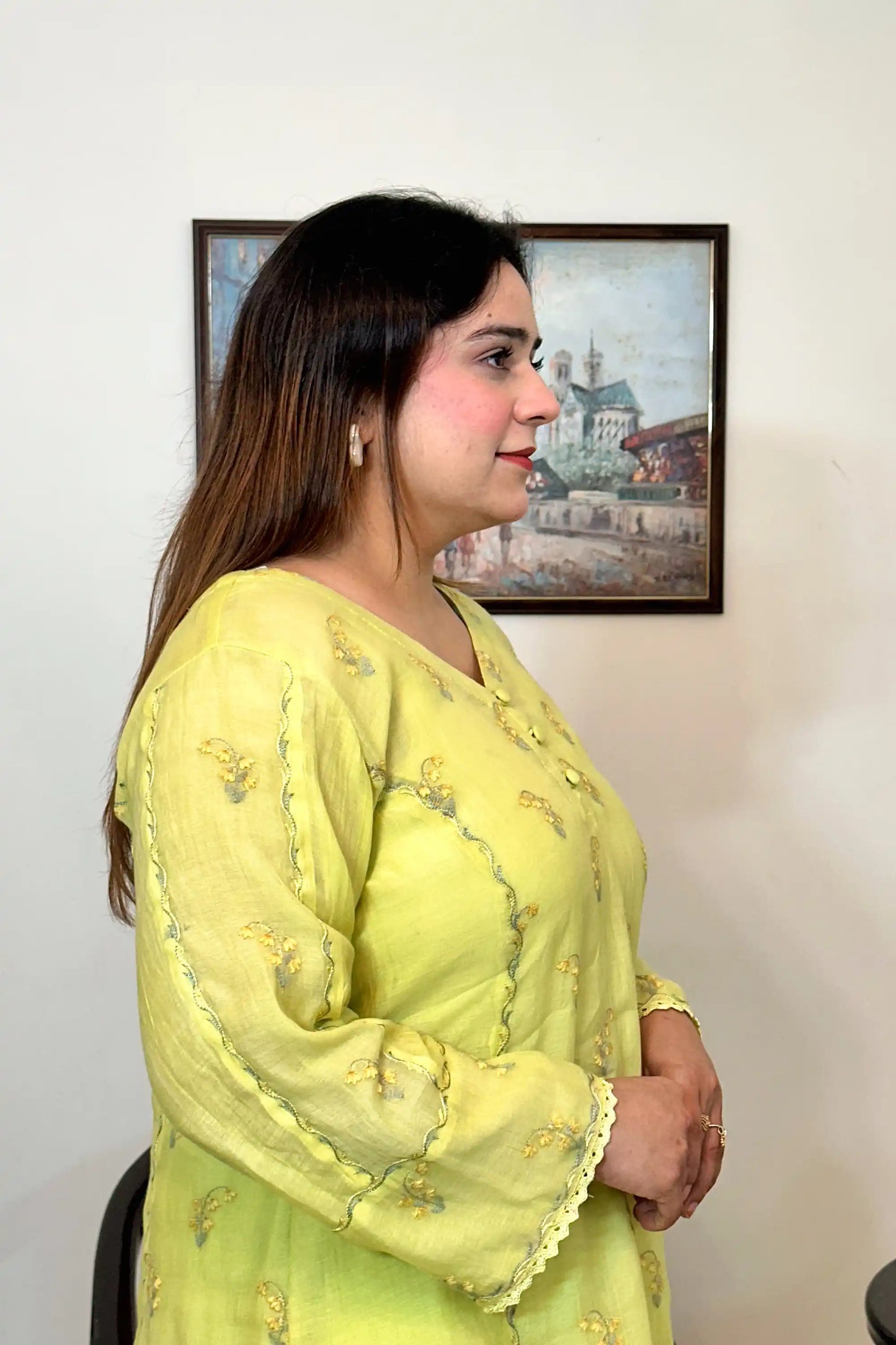 Side view close-up of a lemon-yellow chanderi kurta, showing floral resham embroidery along the button placket and sleeve.