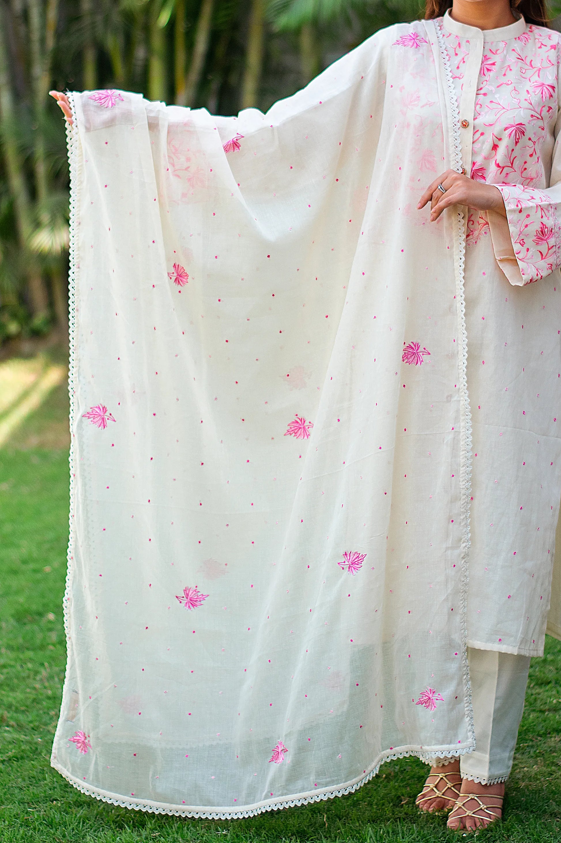 Indian model showcasing an off-white dupatta with pink kashmiri flowers and  pink dots and lace borders.