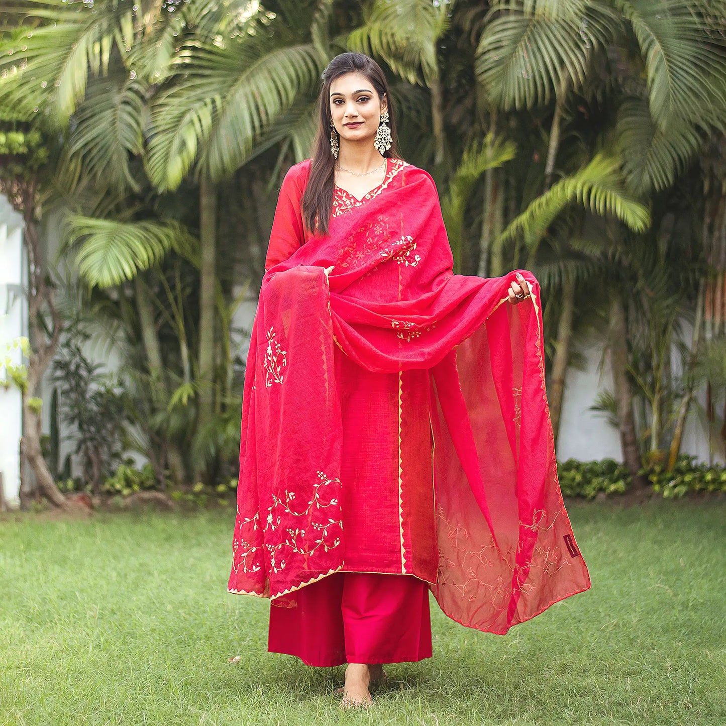 Indian woman wearing a red jute silk kurta and chanderi dupatta with beige applique work, paired with a red palazzo.