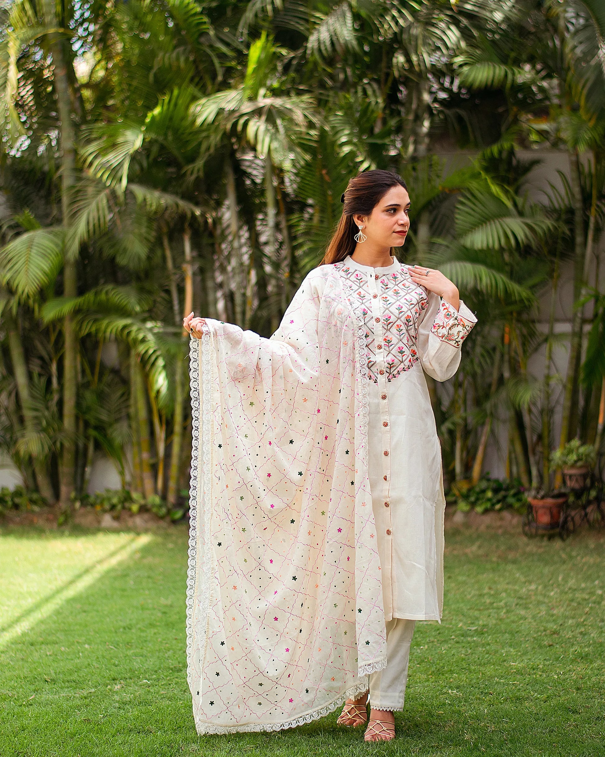 Indian girl dressed in an off-white cotton kurti with Kashmiri embroidery, complemented by a matching dupatta and trousers.