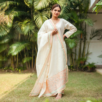  Indian woman in an off-white chanderi kurta with pastel piping, complemented by a pastel patchwork dupatta and matching palazzo.