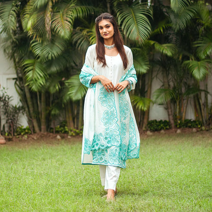 Model wearing the off-white Chanderi suit with cyan green floral cutwork, posed elegantly