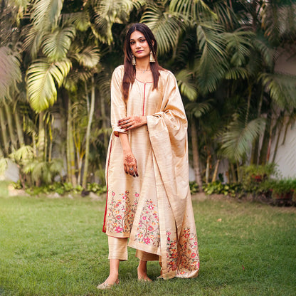 Indian model in a beige silk kurta with resham weave, paired with a matching beige dupatta and trousers.