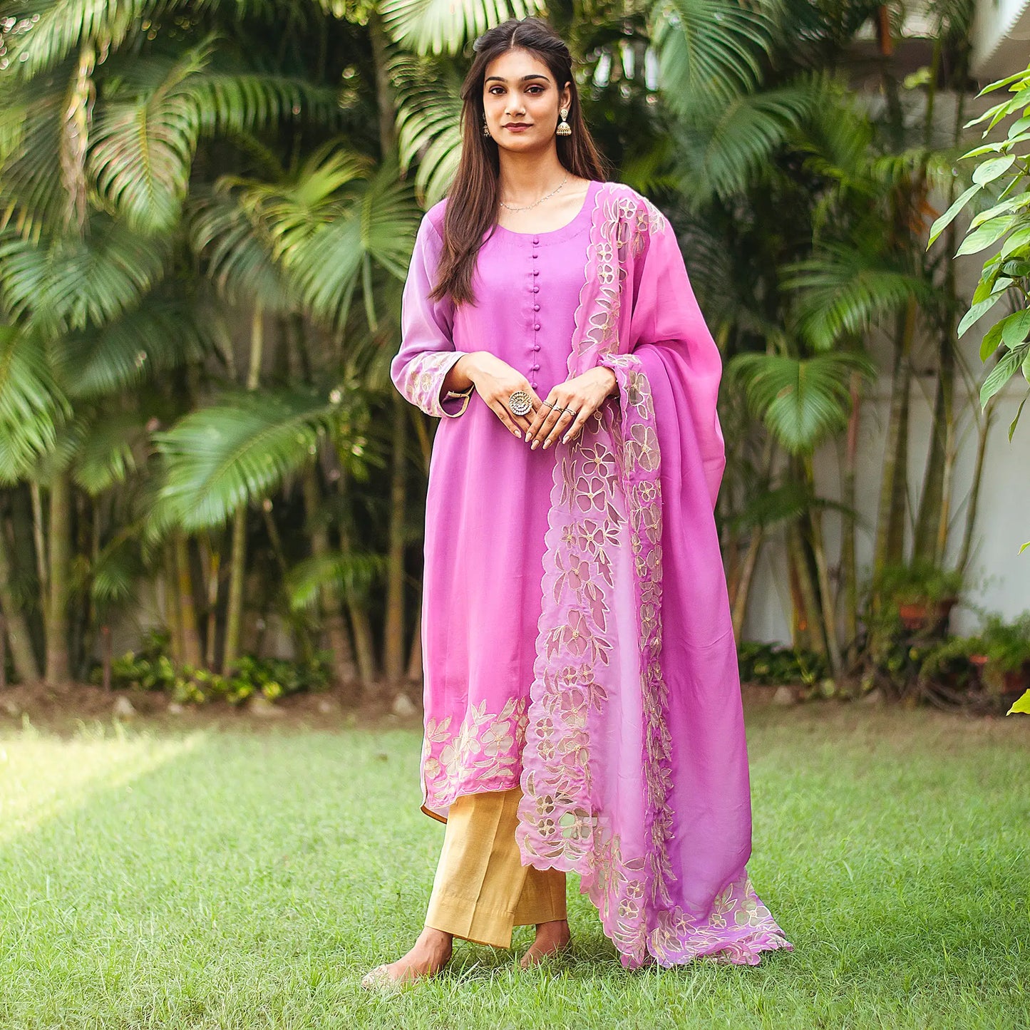 Indian model in a light purple kurta set, featuring golden floral cutwork on both the kurta and dupatta, completed with gold trousers.