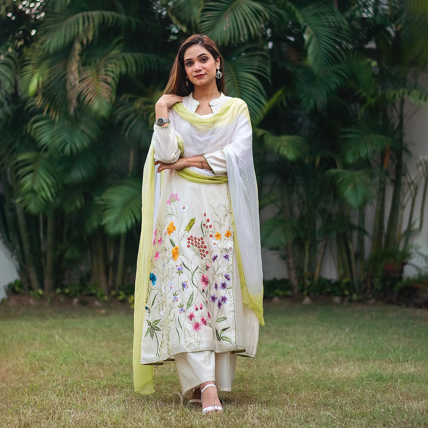 ndian model in an off-white angrakha kurta with resham embroidery, paired with a flowy chiffon dupatta and palazzo.