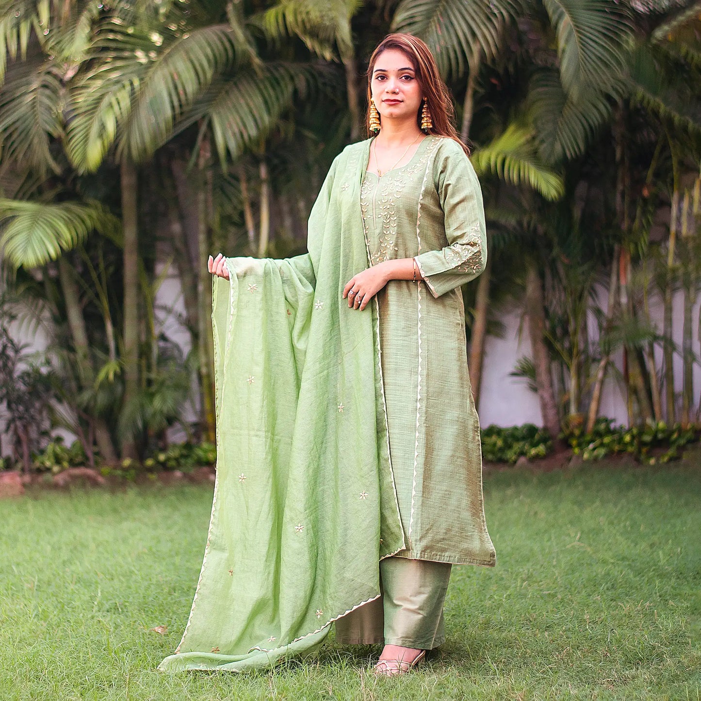 Indian lady poses in a green jute silk kurta and chanderi dupatta with beige applique work, complemented with a green palazzo.