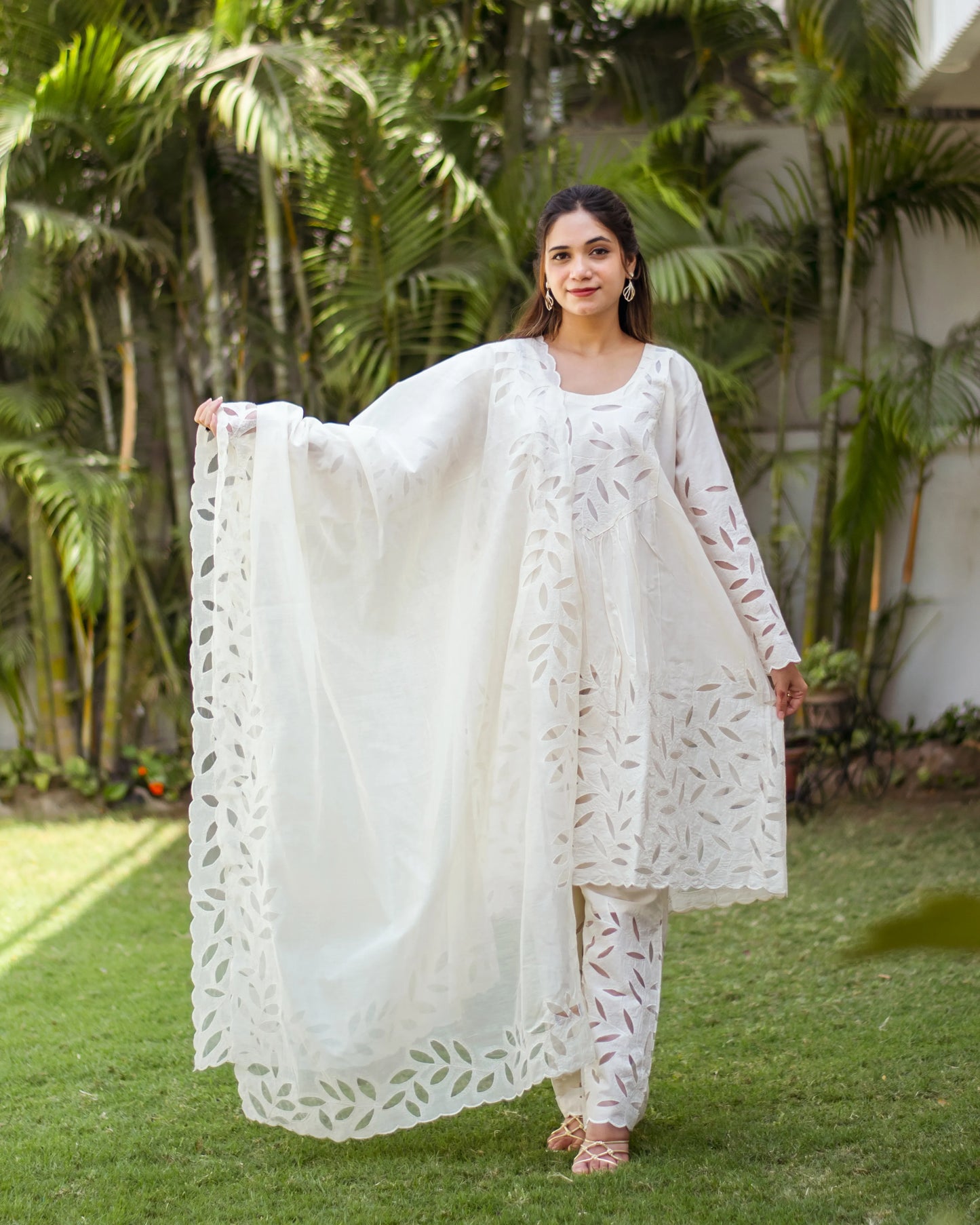 Model in a white A-line kurta set with intricate floral embroidery.