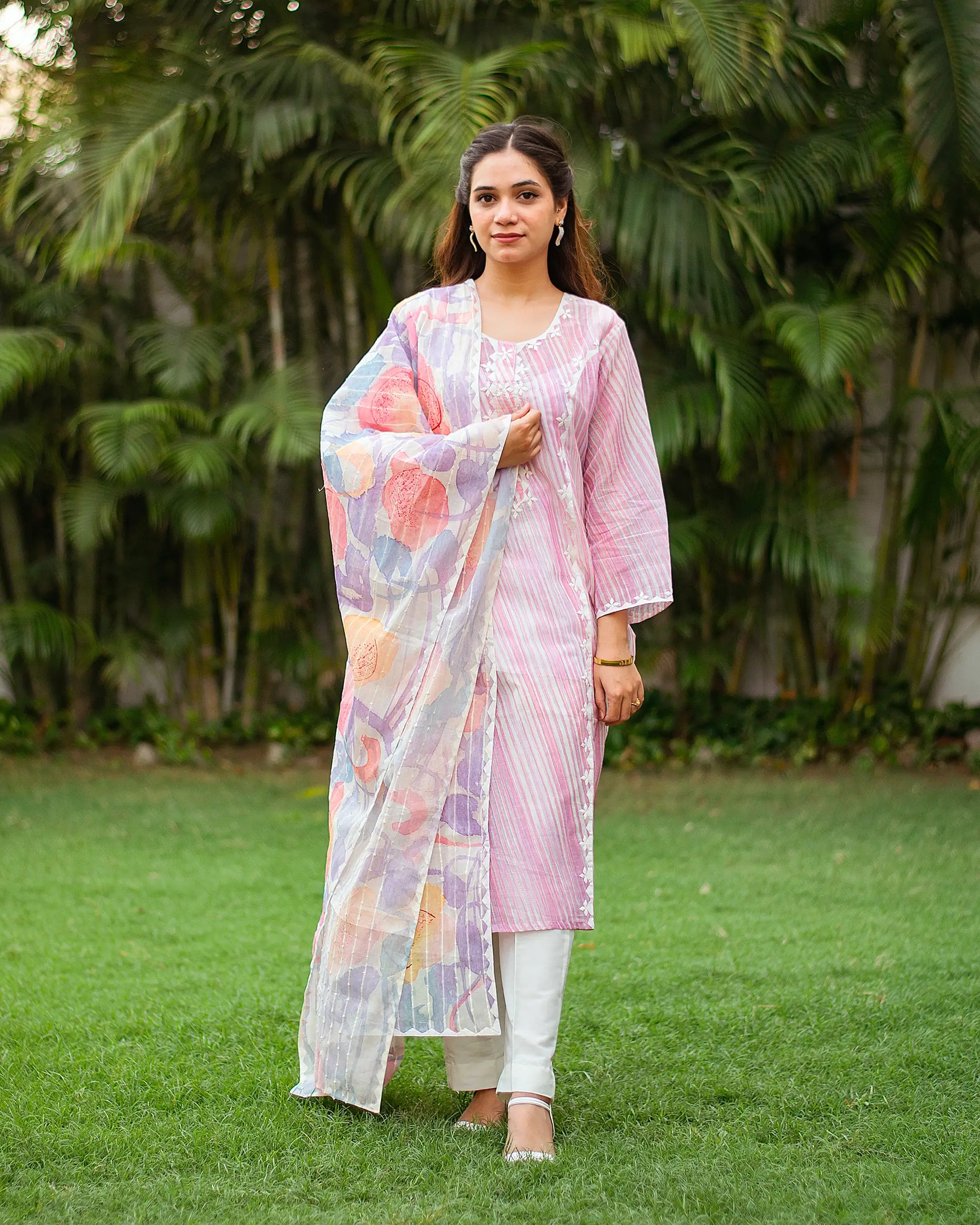 Indian woman wearing a baby pink kurta set with abstract printed dupatta. 