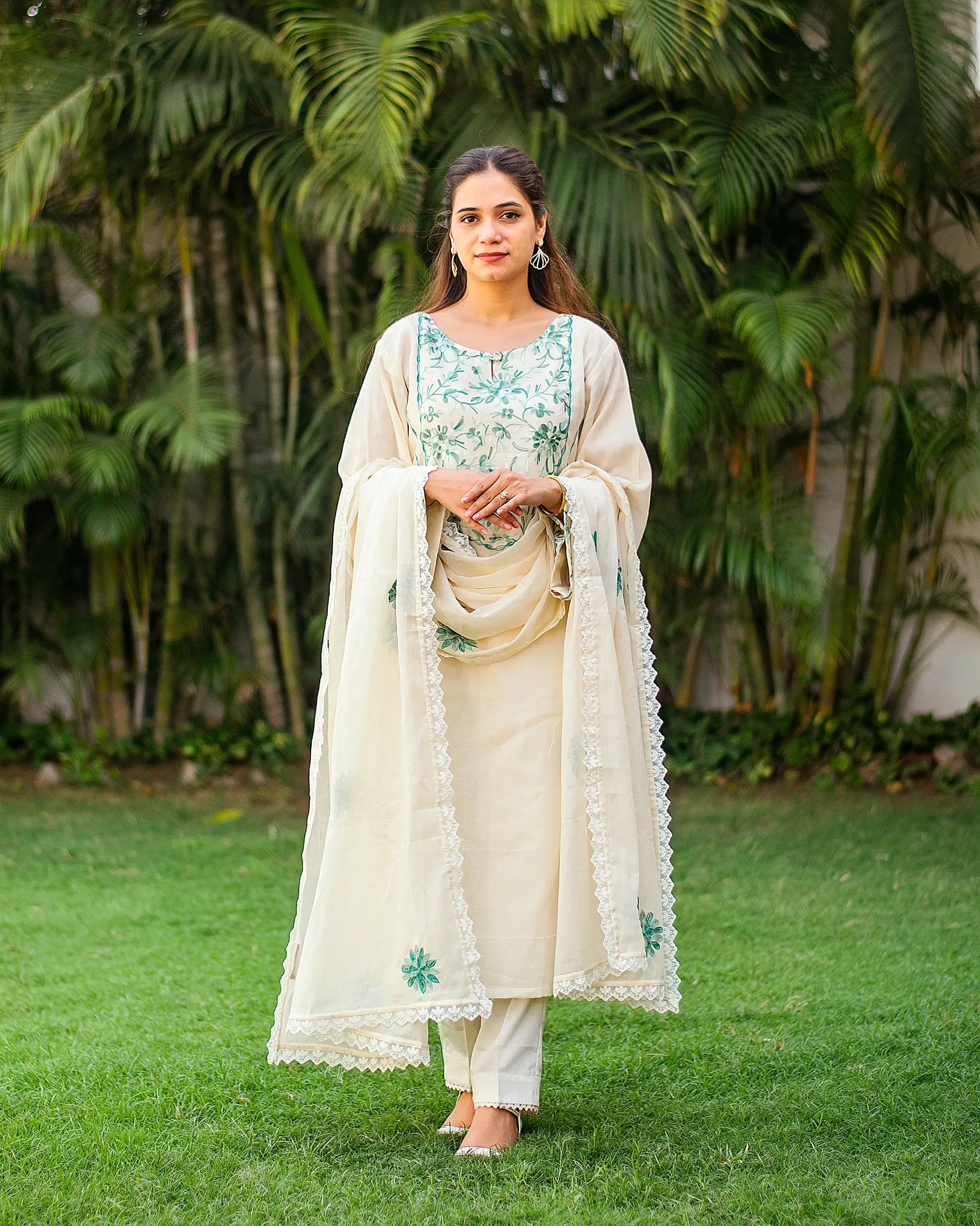  Indian woman wearing an embroidered kurti set with floral green thread work.